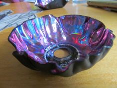 a purple glass bowl sitting on top of a wooden table