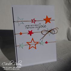 a white card with red, orange and green stars hanging from it's sides