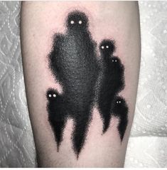 some black ink tattoos on the leg of a person's arm with three ghost silhouettes