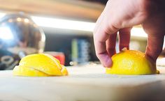 a person is peeling an orange on a cutting board