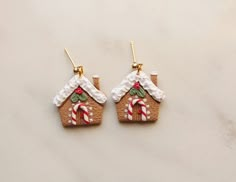 the gingerbread house earrings are decorated with candy canes