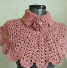 a pink crocheted shawl on top of a mannequin headdress