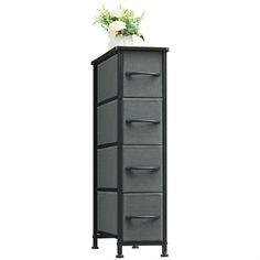 a tall cabinet with five drawers and flowers on top