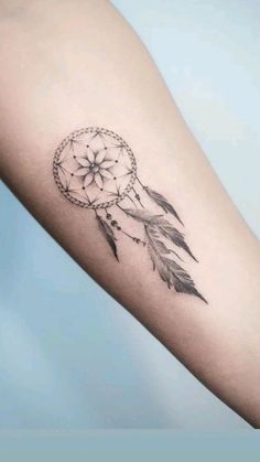 a small dream catcher tattoo on the arm