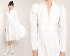 "FEATURES - 1970s / early 1980s dress - Gunne Sax label - Cream color - Edwardian style - Split neckline with a high neck collar and pearl beaded and lace trim - Buttons up the chest - Pleated detail up the chest - Leg O' Mutton sleeves with lace cuffs - Fitted waistline with a tie and ribbon trim - Midi length skirt with a large sweep and flutter hem - Zips up the back (zipper does not go to the very top of the neck) Note: dress is more cream than pictured in the photos. CONDITION Great vintage Fitted Regency Vintage Dress With Ruffles, Fitted Victorian Wedding Dress For Winter, Fitted Vintage White Victorian Dress For Formal Occasions, Fitted Victorian Dress In Vintage White For Formal Occasions, Formal Fitted Vintage White Victorian Dress, Formal Fitted Victorian Dress In Vintage White, Elegant Victorian Dress For Fall Wedding, Formal Fitted Victorian Dress For Spring, Fall Wedding Vintage Dress