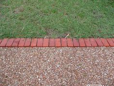 a red fire hydrant sitting on top of a sidewalk next to a patch of grass