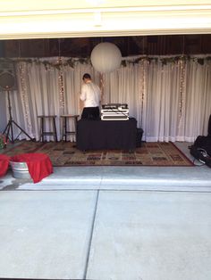 a man standing in front of a stage set up for an event with white curtains and lights