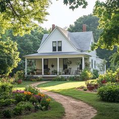 a white house sitting in the middle of a lush green field