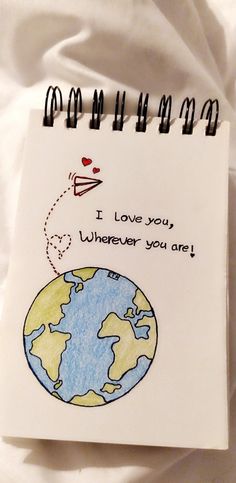 a notepad with a drawing of the earth on it that says i love you wherever you are