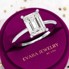 a diamond ring sitting on top of a purple box