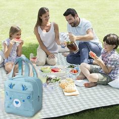 a family sitting on the grass eating and having a picnic in the park with their child's lunch bags