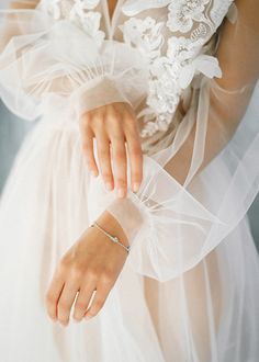 a woman wearing a wedding dress and holding her hand on the waist with a ring