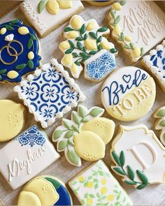 some decorated cookies are laying on a table with blue and yellow designs, one is for bride and the other is for groom