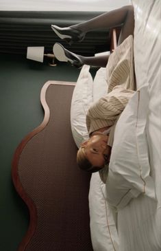 a woman laying on top of a bed next to a pillow and hair dryer