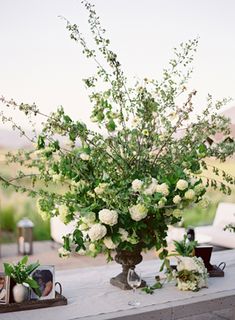 a vase filled with white flowers sitting on top of a table next to other items