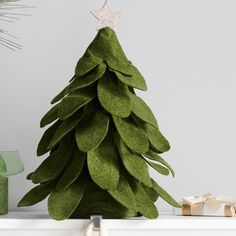 a green christmas tree sitting on top of a white shelf