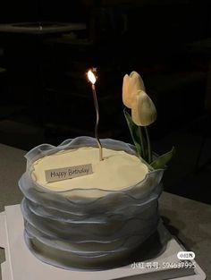 a birthday cake with a single flower on top