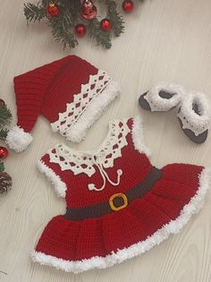 a crocheted christmas outfit and slippers on the floor