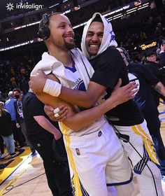 two basketball players hugging each other on the court