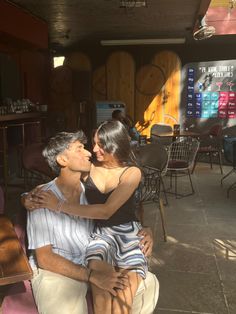 a man and woman hugging each other in front of a bar