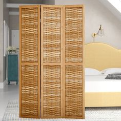 a room divider made out of wicker with a bed in the background