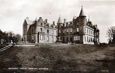 an old black and white photo of a castle with stairs leading up to the front