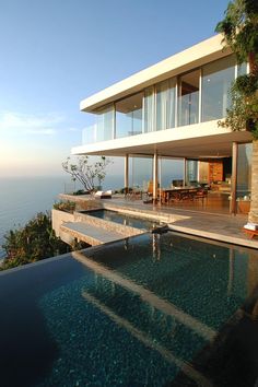 the house is overlooking the ocean and has a swimming pool