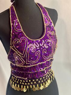 Add a touch of glamour to your raqs (belly dance) outfits with this stunning handmade beads, sequin, coins, and tassels belly dancing top. Crafted for elegance and performance, it shines beautifully under stage lights, making it a perfect addition to your dance wardrobe. This women's fashion bra top is not only ideal for belly dance but also suitable for raves, dances, clubwear, and various occasions like zumba, yoga classes, parties, and stage performances. It's designed to enhance your appearance and confidence wherever you wear it, including in photographs. For washing care, treat it delicately by washing it by hand in 35-degree water, hanging to dry in the shade, and avoiding bleaching to maintain its intricate details and vibrant colors. Elevate your dance ensemble with this exquisite Intricate Embroidered Purple Blouse For Festivals, Purple Mermaid Top, Elegant Purple Bra With Lace Trim, Belly Dance Bra Design, Purple Belly Dance Costume, Purple Bras, Sequin Halter, Belly Dance Outfit, Bra Items