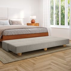 a large bed sitting on top of a hard wood floor next to a wooden dresser