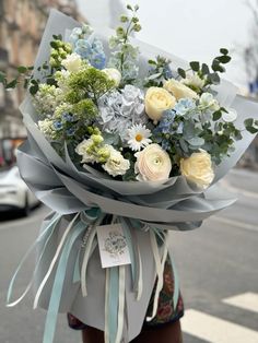 a woman holding a bouquet of flowers on the street