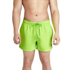 a man in green swim trunks with no shirt on, standing up and looking at the camera