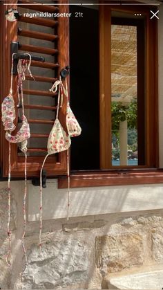 three bras hanging from the side of a window sill in front of a stone building