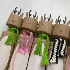 several rolls of toilet paper decorated with deer heads and scarves on top of each other