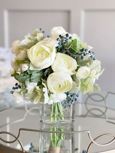 a vase filled with white flowers on top of a glass table