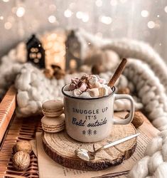 a mug filled with marshmallows sitting on top of a wooden table