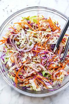 a glass bowl filled with coleslaw and carrots