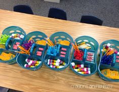 several plastic containers filled with school supplies on a table