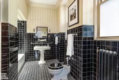 a bathroom with black and white tiles on the walls