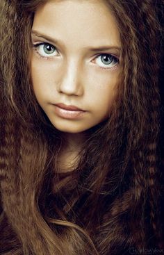 a woman with long hair and blue eyes