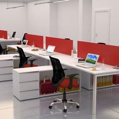 an office cubicle with two desks and laptop computers on each one, along with red dividers