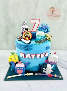 a blue birthday cake with cartoon characters on it's top and the number seven