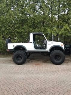 a white truck parked on top of a brick road