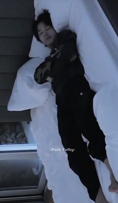 a man laying in bed with his head on the pillow