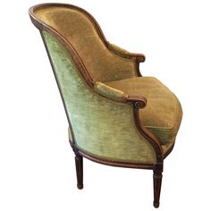 an old fashioned chair with green velvet upholstered on the back and armrests