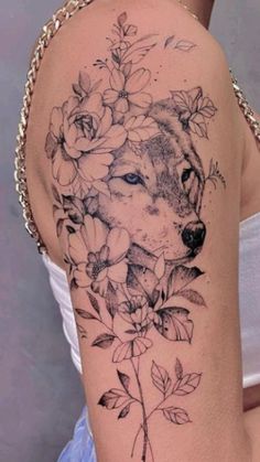 a woman's shoulder with flowers and a wolf on it