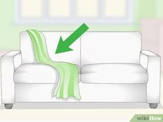 a white couch with a green blanket on it and an arrow pointing to the right