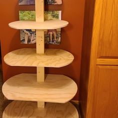 three tiered wooden shelf with pictures on it