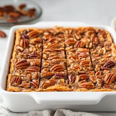 a white dish filled with pecan bread on top of a table