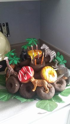 there are many toy animals in the middle of a cake on top of a table