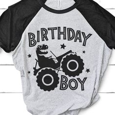 a gray and black birthday shirt with an image of a dinosaur riding a monster truck